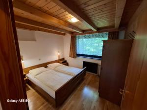 a small bedroom with a bed and a window at Haus Mooswald in Lechleiten