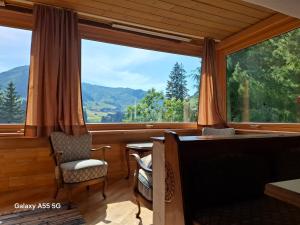 a room with a large window with a desk and a table at Haus Mooswald in Lechleiten