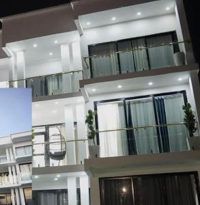 ein großes weißes Gebäude mit schwarzen Fenstern in der Unterkunft Cross Suites in Tema