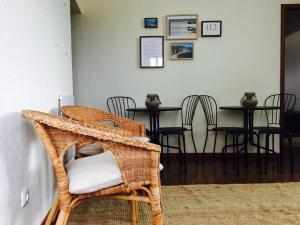 a dining room with a wicker chair and a table at Alojamento Espigas in Azoia