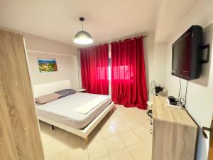 a bedroom with a bed and a red curtain at Luna Apartment in Durrës +29 photos