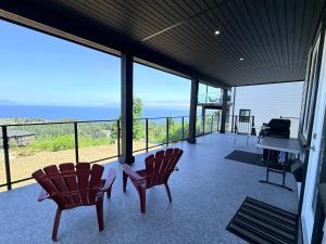 eine überdachte Veranda mit zwei Stühlen und einem Klavier in der Unterkunft Ocean Whispers in Nanaimo