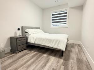 ein Schlafzimmer mit einem Bett, einer Kommode und einem Fenster in der Unterkunft Ocean Whispers in Nanaimo + 12 Fotos