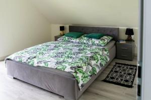 a bedroom with a bed with a green and white comforter at Domek pod Nowiną in Tylmanowa