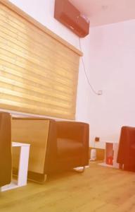 a living room with a couch and a tv on a wall at M & A Homes Ilorin in Ilorin