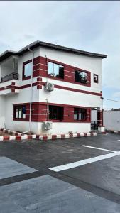 a red and white building in a parking lot at M & A Homes Ilorin in Ilorin