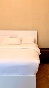 a bed with white sheets and pillows in a room at In The Peaks in Sharīyah