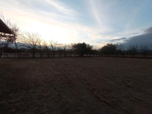 an empty field with the sun in the sky at Cabaña LDM cc in Santa Rosa