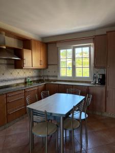a kitchen with a table and chairs and a window at Casa Mar de Neaño in Neaño