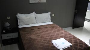a bedroom with a bed with a brown blanket and white pillows at Lux hotel in Tbilisi City
