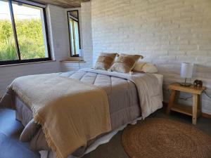 a bedroom with a large bed and a window at La Choza - Refugio para dos in La Falda