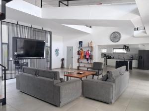 a living room with two couches and a flat screen tv at Mais Residence in Bijilo