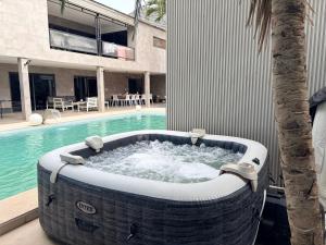 a large bath tub sitting next to a swimming pool at Mais Residence in Bijilo