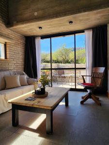 a living room with a couch and a table at La Choza - Refugio para dos in La Falda