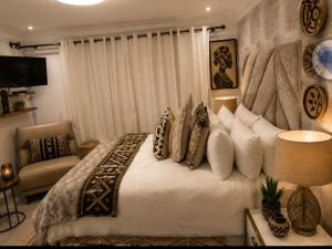 a bedroom with a large bed with pillows at Eluthando Guesthouse in St Lucia
