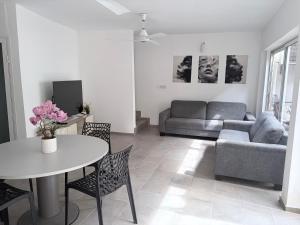 a living room with a table and a couch at Mais Residence in Bijilo