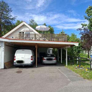 a white van parked in a garage with a balcony at Charming room with big bed in Luleå