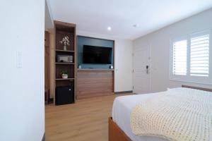 a bedroom with a bed and a flat screen tv at Nox Hotel - Studio City in Studio City +16 photos