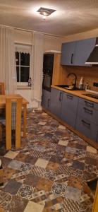 a kitchen with a tile floor and a table with a sink at Dehmkerhof in Aerzen
