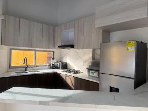 a kitchen with a stainless steel refrigerator and a sink at Cabaña Sueños del Mar in Santa Marta