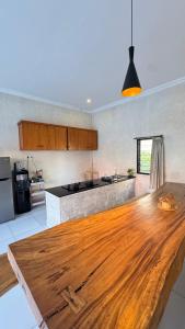 a kitchen with a wooden table in the middle at Vila Billy II in Munggu