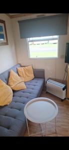 a living room with a blue couch and a table at Clonvilla Mobile Chalet in Cromponn Bridge