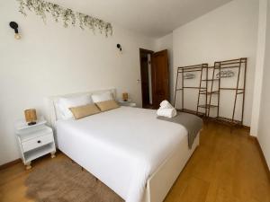a bedroom with a large white bed and a wooden floor at El Pasaje del Marqués in El Burgo de Osma