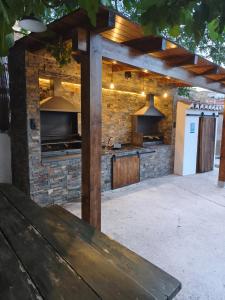 an outdoor kitchen with a stone wall and a wooden bench at Cuevas Uropia in Graena
