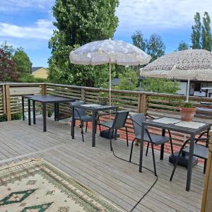 two tables and chairs with umbrellas on a deck at Charming room with big bed in Luleå +5 photos