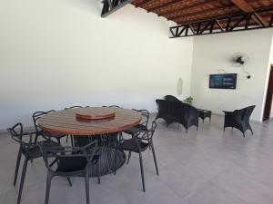 a dining room with a wooden table and chairs at Casa Dunas douradas in Barreirinhas