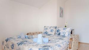 a bedroom with a bed with blue and white sheets at Atina Apartments in Peštani
