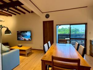 a living room with a dining room table and a couch at 鴨川ビーチハウス in Kamogawa