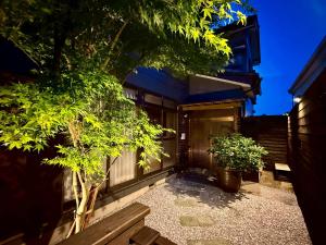 a house with a tree in front of a building at 鴨川ビーチハウス in Kamogawa