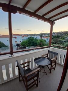 a balcony with a table and chairs and a view at Villa Joanna in Batsi +5 photos