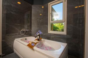 a bathroom with a bath tub with a window at Marvera Hotel in Fethiye +20 photos
