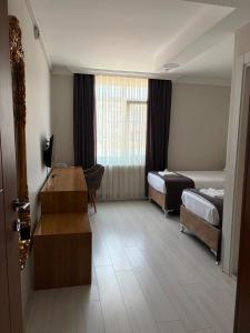 a hotel room with two beds and a desk at Gölpark Otel in Yeniçağa +5 photos