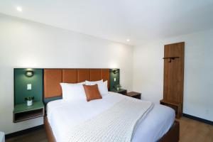 a bedroom with a large bed with a wooden headboard at Nox Hotel - Studio City in Studio City