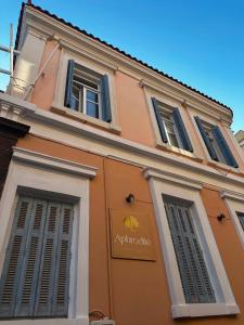 a building with two windows and a sign on it at Aphrodite luxury rooms in Mytilene
