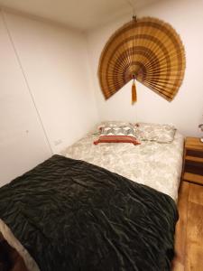 a bedroom with a bed with a fan on the wall at Rustika Tiny House in Pucón