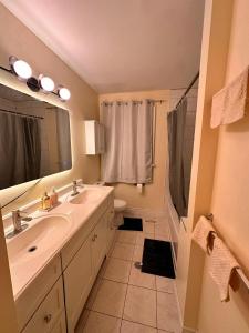 a bathroom with a sink and a toilet and a mirror at Treverton Retreat in Toronto