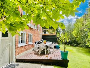 a patio with a table and chairs in a yard at Whitby Studio - Mairangi Bay Beach in Auckland
