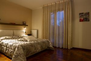 a bedroom with a bed and a large window at La Gardenia in Montecatini Terme
