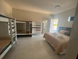 a bedroom with two bunk beds and a room with at Manero Pousada e Hostel NATAL in Natal