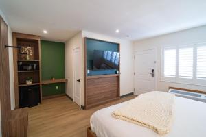 a bedroom with a bed and a flat screen tv at Nox Hotel - Studio City in Studio City