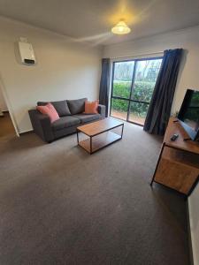 a living room with a couch and a coffee table at Raceway Lodge in Feilding