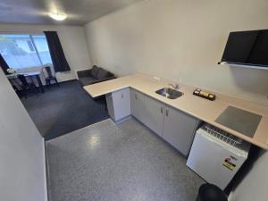 a small kitchen with a sink and a counter top at Raceway Lodge in Feilding