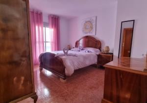 a bedroom with a bed with a wooden headboard and a mirror at Gran Areatxa Home Mountain in Santiago de la Espada