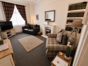 a living room with a couch and a fireplace at Hillhead Apartment in Coylton