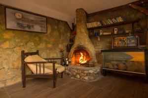 a living room with a stone fireplace and a chair at Marvera Hotel in Fethiye