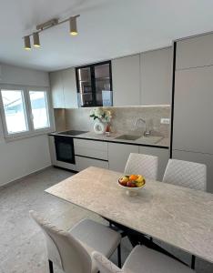 a kitchen with a table with a bowl of fruit on it at Apartment Dolce by DuBooker in Trpanj